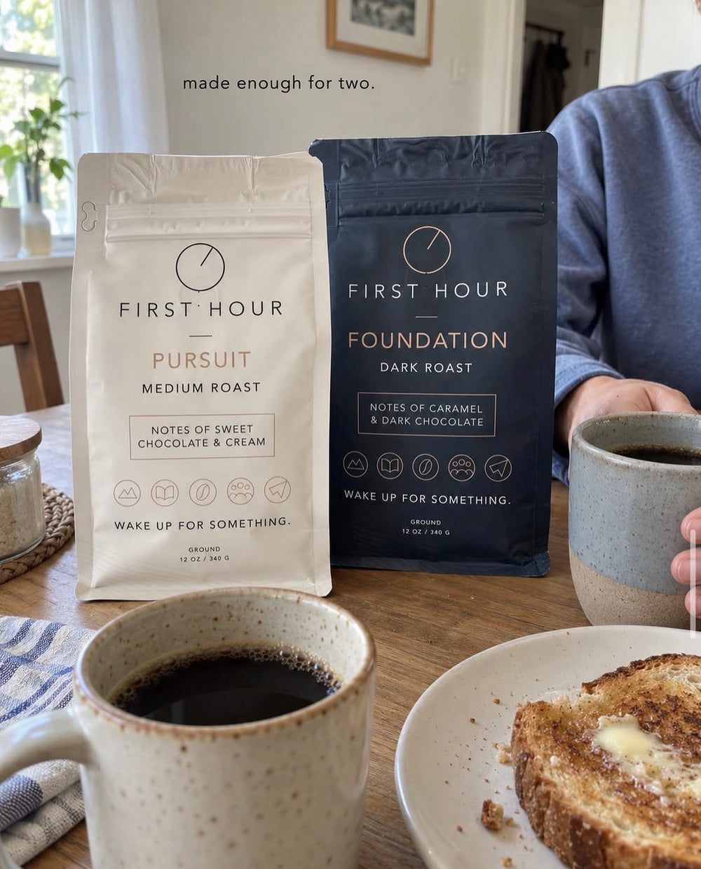 Pursuit and Foundation coffee bags on a breakfast table beside a mug of coffee.